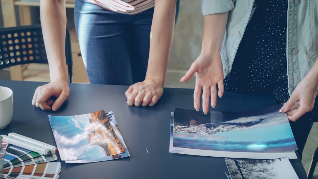 Small editorial team reviewing photographs at a bright office table